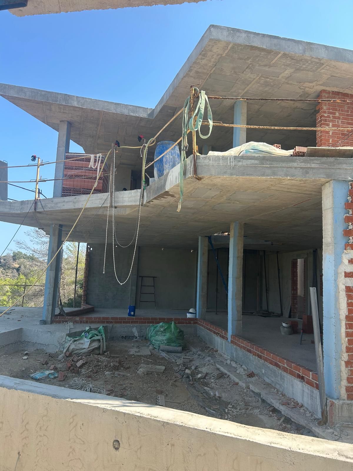 Fase de estructura de una vivienda multinivel en Benitachell, con forjados de hormigón armado, pilares y tabiquería inicial de ladrillo.