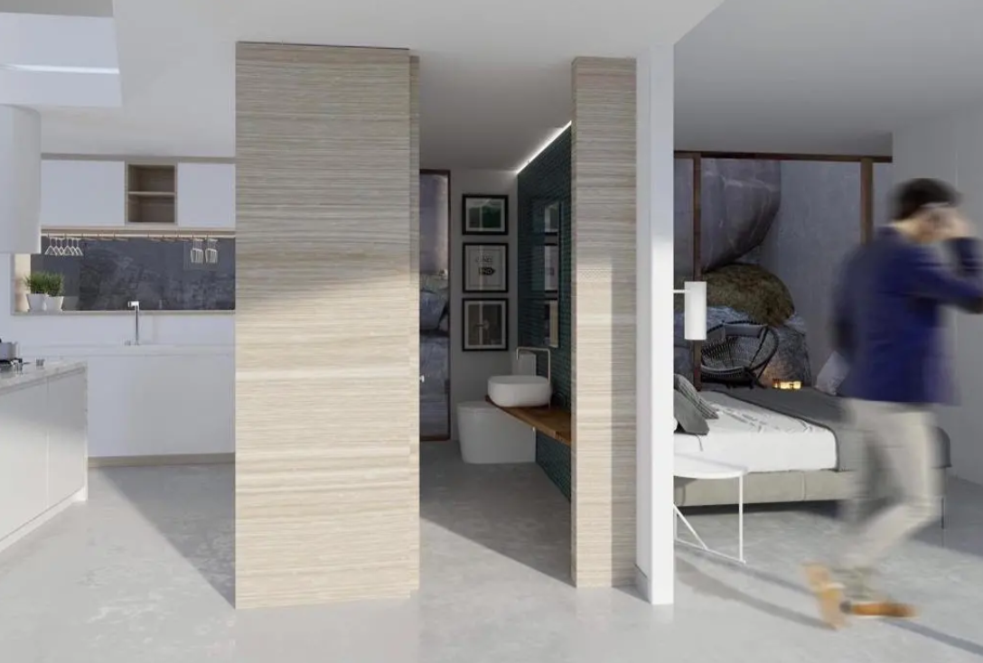 Suite de concepto abierto con cocina integrada, baño en suite con lavabo sobre encimera de madera y dormitorio con vistas a roca natural. Divisiones en madera clara.
