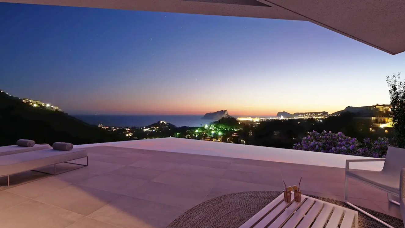 Terraza con piscina infinita y vistas panorámicas de la costa al atardecer. Incluye pavimentos de gran formato, mobiliario exterior de diseño y vistas al Peñón de Ifach.
