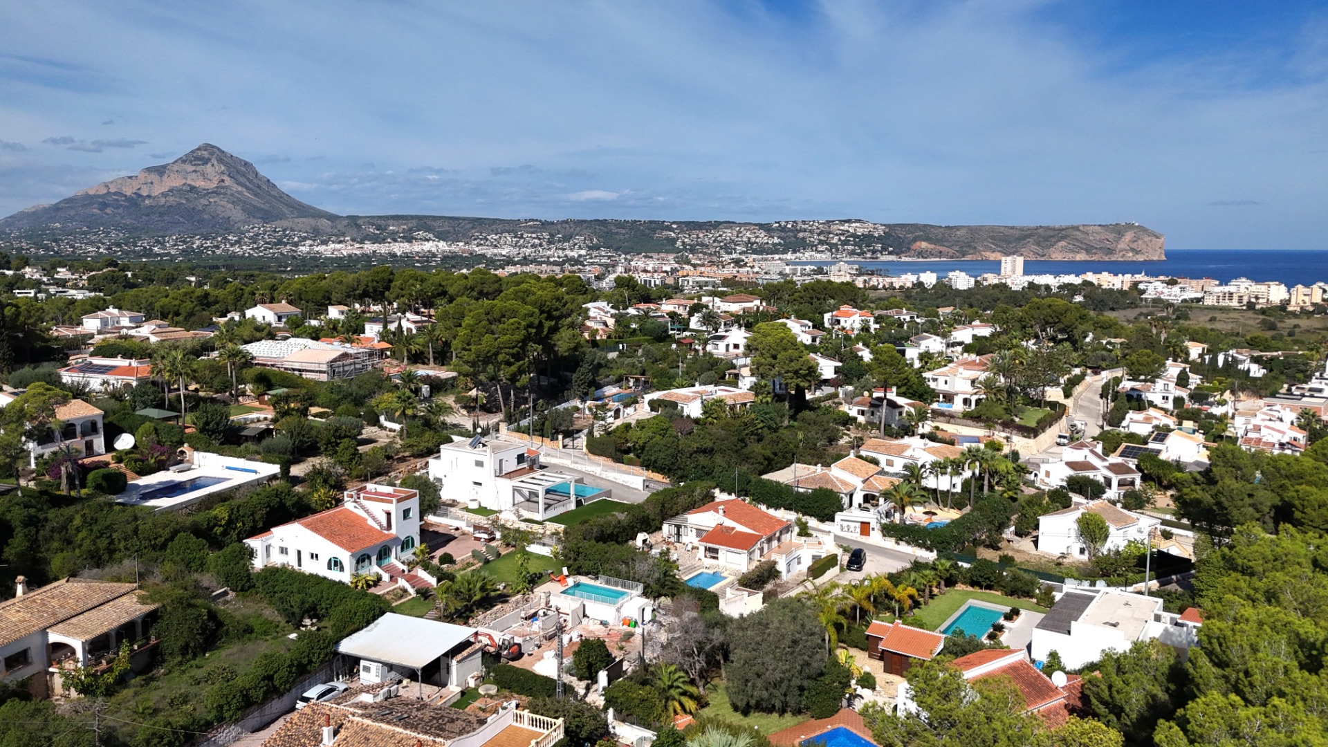 Vista aérea panorámica de la zona de Toscal en Jávea, destacando el macizo del Montgó, el Cabo de San Antonio y la costa mediterránea bajo un cielo despejado.