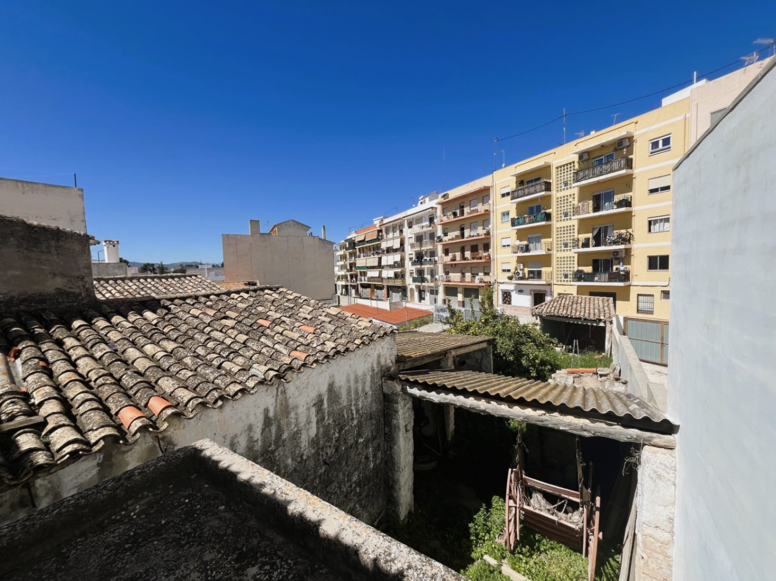 Vista elevada sobre el patio trasero y los tejados tradicionales de teja árabe, integrando la propiedad en el entorno urbano del casco antiguo de Jávea.