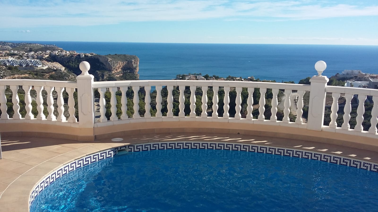 Vista de la piscina con barandilla blanca y vistas al mar en Cumbre del Sol, Benitachell.