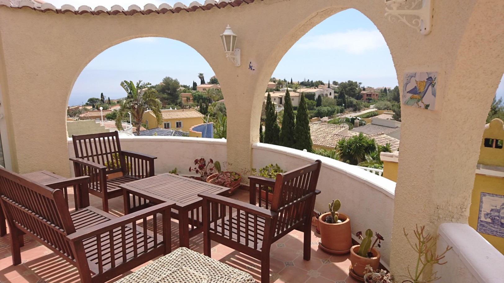 Terraza circular con arcos mediterráneos, mobiliario de madera y vistas panorámicas al mar y a la urbanización Cumbre del Sol.