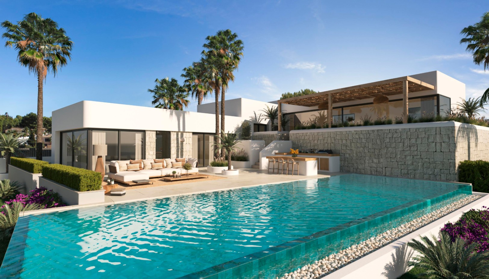 Exterior de villa moderna con piscina de borde infinito, zona de estar al aire libre y cocina exterior bajo un muro de piedra natural y palmeras.