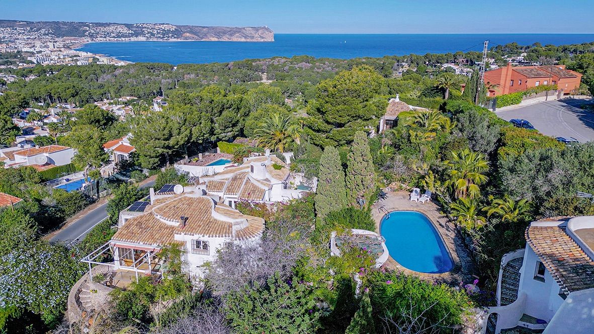 Vista aérea de la propiedad en Portichol con tejados de terracota, paneles solares, piscina privada y vistas panorámicas a la bahía de Jávea y el mar Mediterráneo.