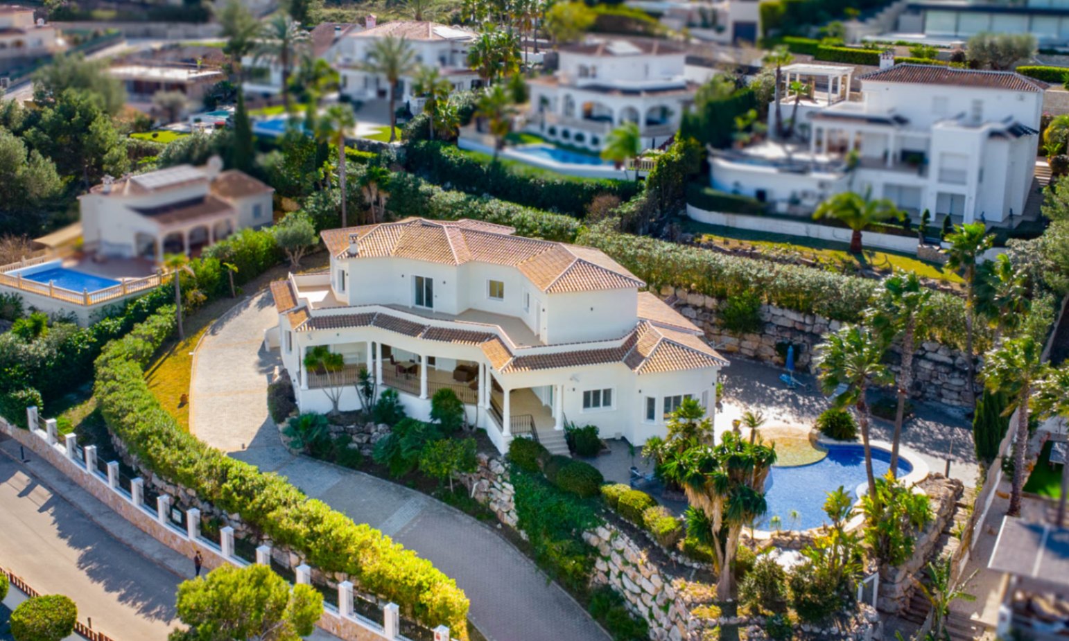 Vista aérea de la villa en Piver, Jávea, destacando su arquitectura mediterránea, tejados de teja y amplia zona de piscina rodeada de vegetación autóctona.